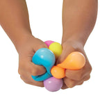 Two hands squeezing 6 NeeDoh Teenie NeeDoh